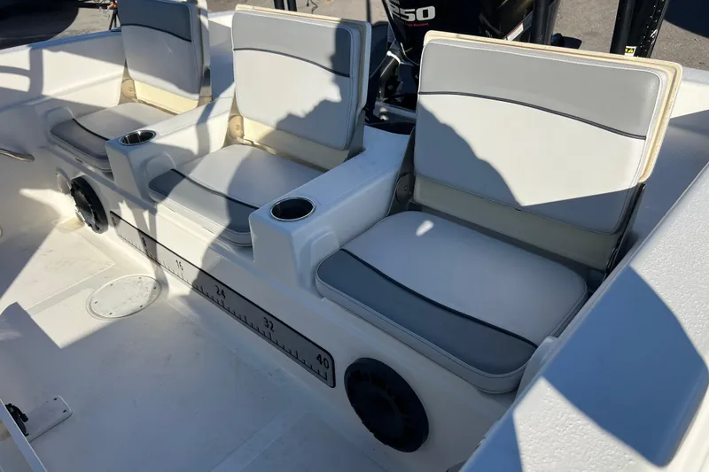 Slide: The Image of 2021 NauticStar 231 Hybrid boat interior with cushioned seats and cup holders. - 17