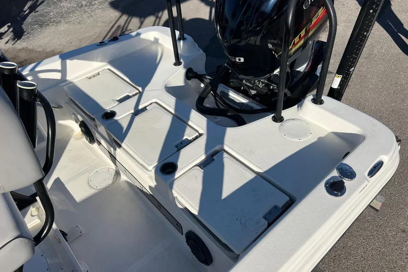 Slide: The Image of 2021 NauticStar 231 Hybrid boat deck with storage compartments and outboard motor. - 18