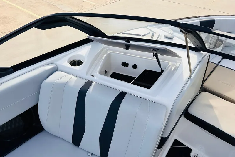Slide: The Image of 2024 Malibu Wakesetter 22 LSV interior with open storage compartment and sleek seating design. - 15