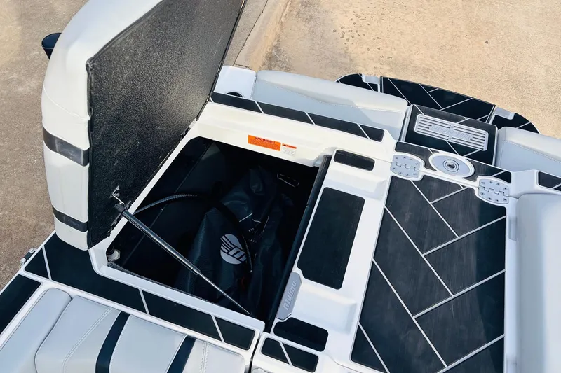 Slide: The Image of 2024 Malibu Wakesetter 22 LSV storage compartment with sleek black and white design. - 36