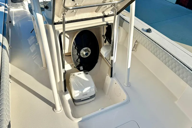 Slide: The Image of 2026 Carolina Skiff 26 Ultra Elite boat interior with storage compartment and portable toilet. - 26