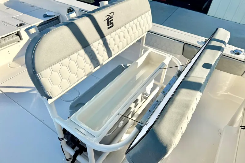 Slide: The Image of 2026 Carolina Skiff 26 Ultra Elite boat seating with storage compartment open. - 31