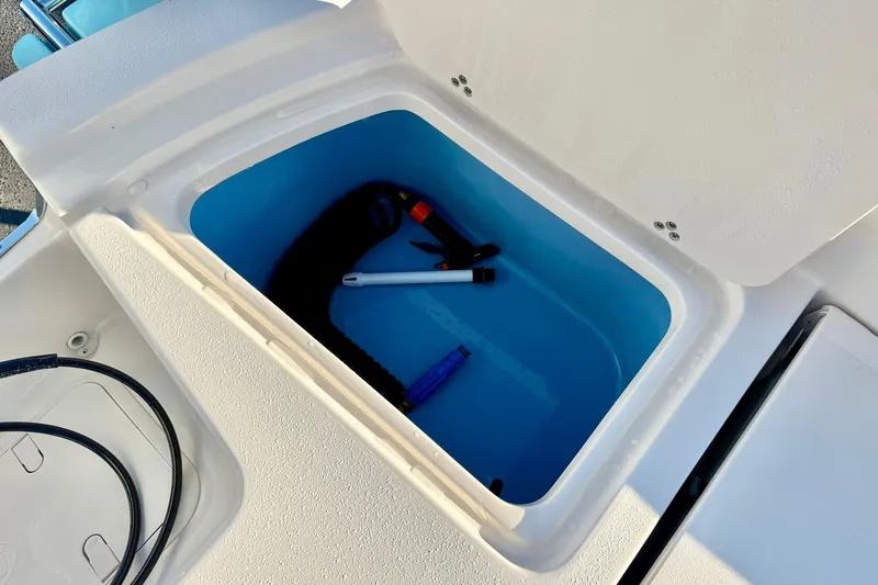 Slide: The Image of Storage compartment on 2026 Carolina Skiff 26 Ultra Elite boat, containing various tools. - 42