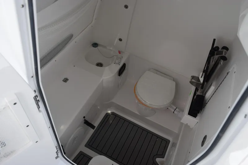 Slide: The Image of Interior of 2026 Sea Hunt Ultra 305 Coffin Box boat, featuring a compact marine toilet. - 17