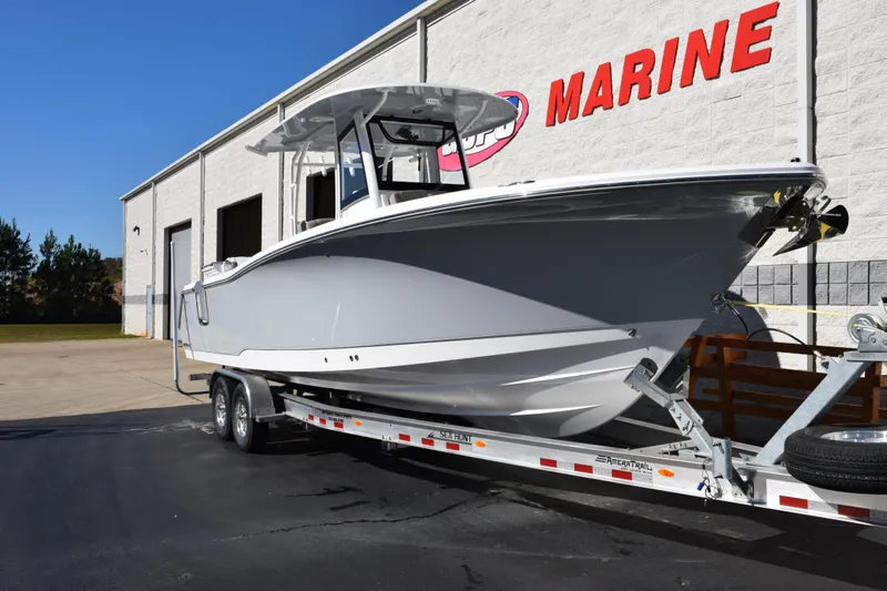 Slide: The Image of 2026 Sea Hunt Ultra 305 Coffin Box boat on trailer outside marine dealership. - 2