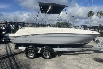 The Image of 2023 Bayliner VR5 Bowrider OB on trailer, parked outdoors under cloudy sky. - 0
