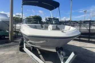 Slide: The Image of 2023 Bayliner VR5 Bowrider OB boat with canopy, parked on a trailer. - 2