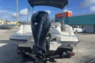 Slide: The Image of 2023 Bayliner VR5 Bowrider OB with outboard motor, parked outdoors under blue sky. - 5