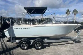 The Image of 2023 Key West 203 DFS boat on trailer, parked outdoors under cloudy sky. - 0