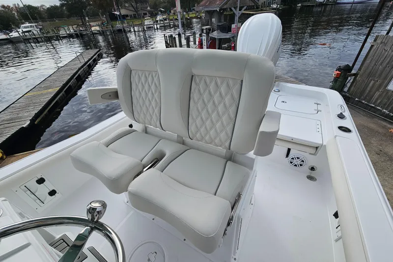 Slide: The Image of 2026 Sea Hunt BX 25 FS boat with luxurious seating, docked by a serene waterfront. - 12