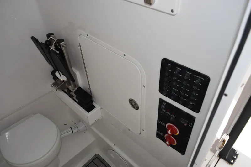 Slide: The Image of Interior of 2026 Sea Hunt Ultra 285 SE boat, featuring control panels and a compact toilet. - 20