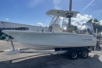 Slide: The Image of 2022 Key West 219 FS boat on trailer, parked outdoors under clear sky. - 4