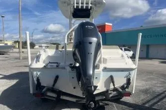 Slide: The Image of 2022 Key West 219 FS boat with outboard motor, parked outdoors under a cloudy sky. - 5