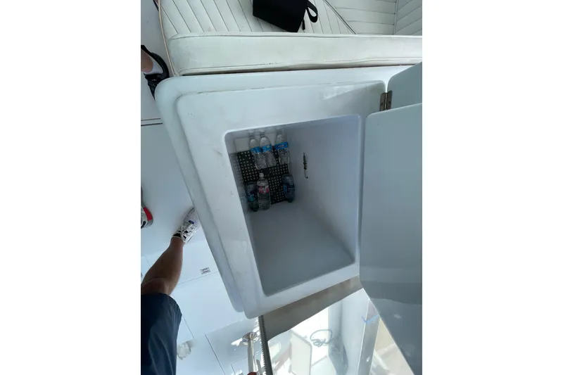 Slide: The Image of Open cooler on Mockingbird Marine Custom 48 boat, showing water bottles inside. - 13