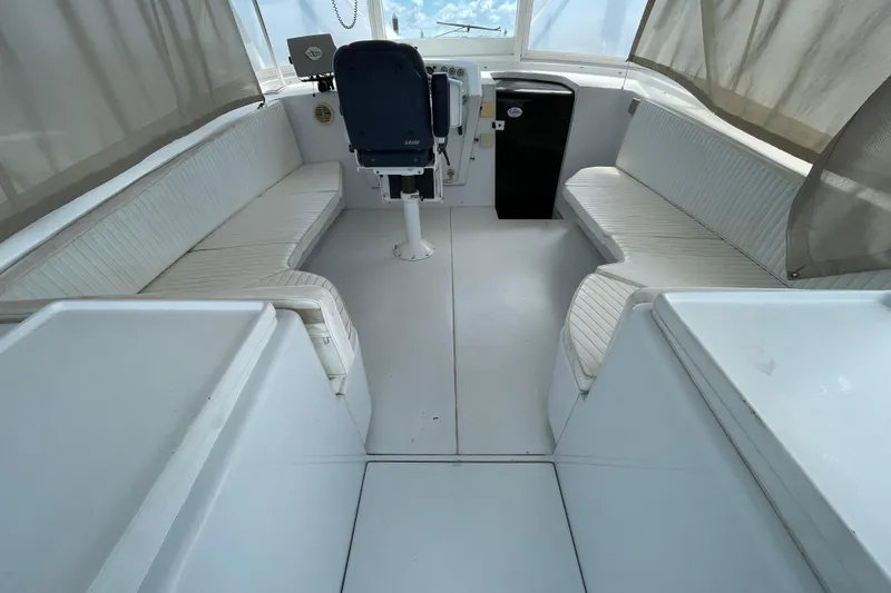 Slide: The Image of Cockpit of 2000 Mockingbird Marine Custom 48 with white seating and helm station. - 19