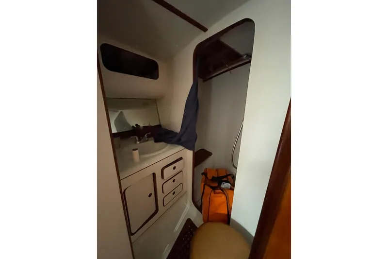 Slide: The Image of Interior of 2000 Custom Mockingbird Marine 48 Sportfish, featuring compact bathroom with sink and storage. - 21