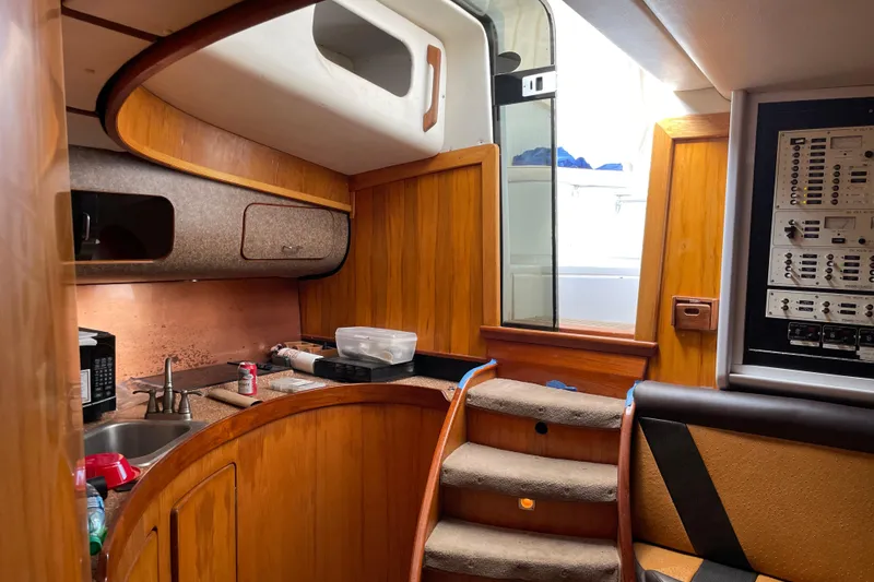 Slide: The Image of Interior of 2000 Custom Mockingbird Marine 48 Sportfish with wood finish and compact kitchen. - 24