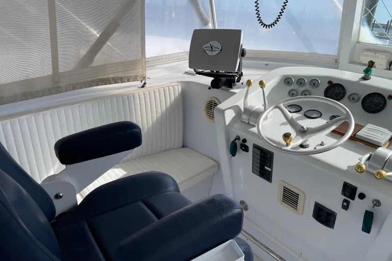 Slide: The Image of Helm of 2000 Custom Mockingbird Marine 48 Sportfish with steering wheel and navigation equipment. - 28