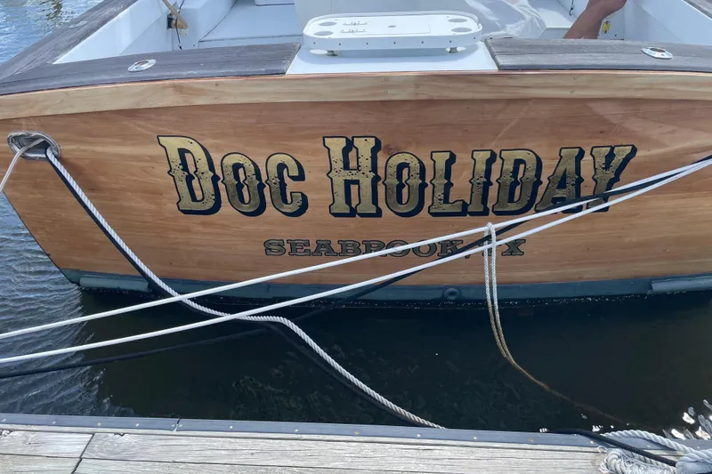 Slide: The Image of Wooden boat stern with "Doc Holiday" text, Mockingbird Marine Custom 48, 2000 model. - 8