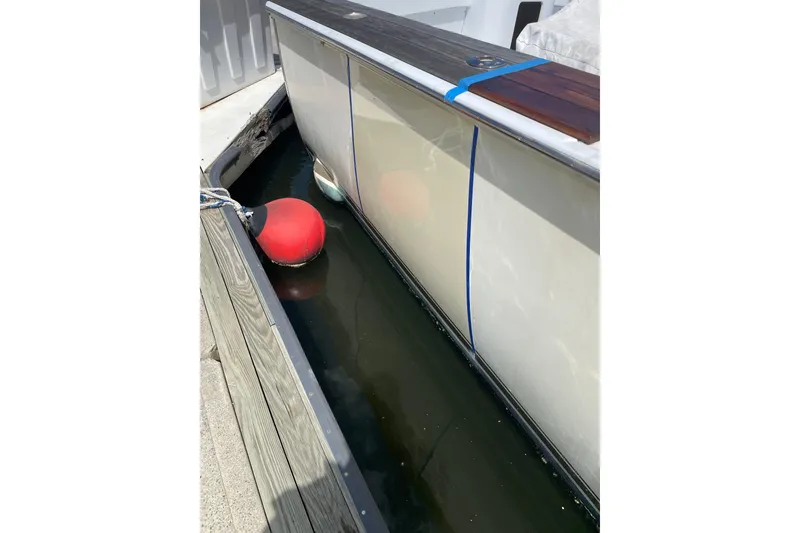 Slide: The Image of Mockingbird Marine Custom 48 boat docked, side view with red buoy, year 2000. - 9