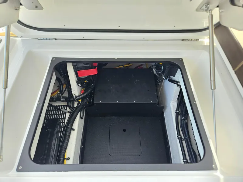 Slide: The Image of 2025 Monterey Elite 27 OB boat storage compartment with organized wiring and equipment. - 13