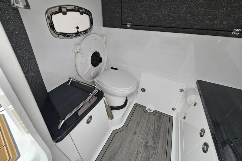 Slide: The Image of 2026 Monterey Elite 27 OB boat bathroom with modern fixtures and wood-style flooring. - 28