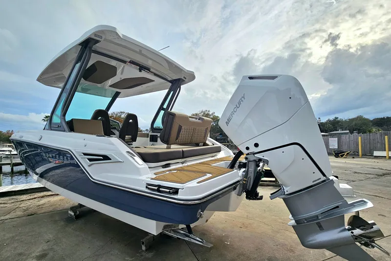 Slide: The Image of 2026 Monterey Elite 27 OB boat with Mercury outboard engine, docked under cloudy sky. - 3