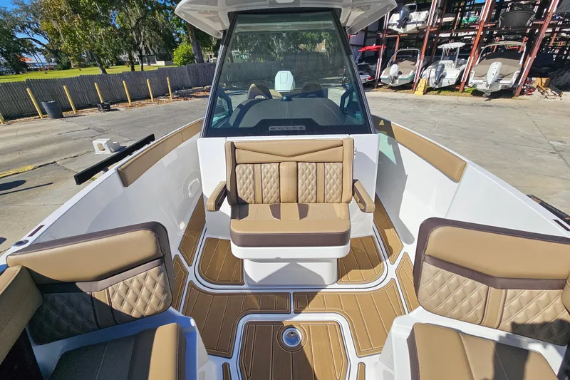 Slide: The Image of 2026 Monterey Elite 27 OB boat interior with tan seating and wood-style flooring. - 33