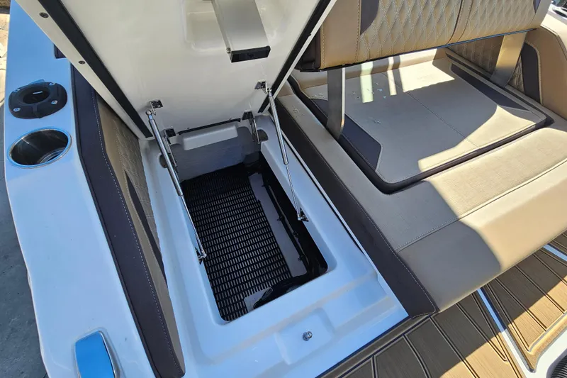 Slide: The Image of 2026 Monterey Elite 27 OB boat with open storage compartment and cushioned seating. - 37