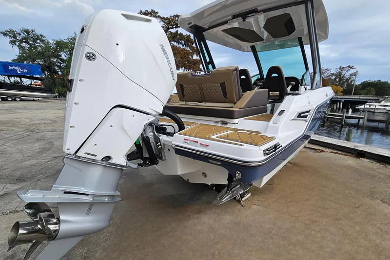 Slide: The Image of 2026 Monterey Elite 27 OB boat with Mercury outboard engine, docked near a marina. - 5