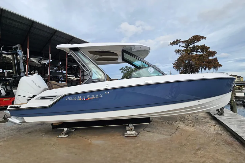 Slide: The Image of 2026 Monterey Elite 27 OB boat, blue and white, docked at marina. - 7