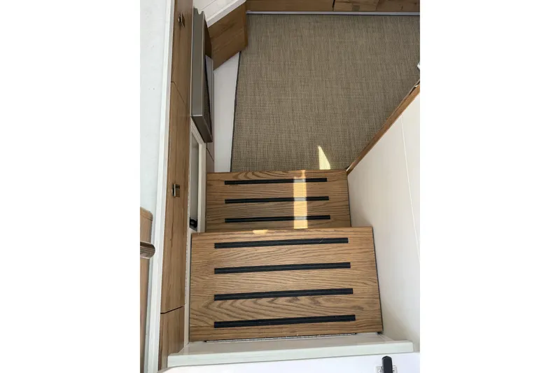 Slide: The Image of 2024 Bertram 39 CC interior stairs with wood finish and carpeted landing. - 17