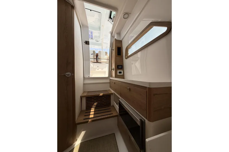Slide: The Image of Interior of 2024 Bertram 39 CC boat, featuring modern wood cabinetry and sleek design. - 22