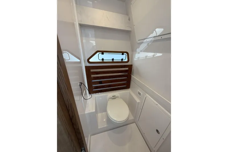 Slide: The Image of 2024 Bertram 39 CC boat bathroom with modern fixtures and wooden accents. - 29