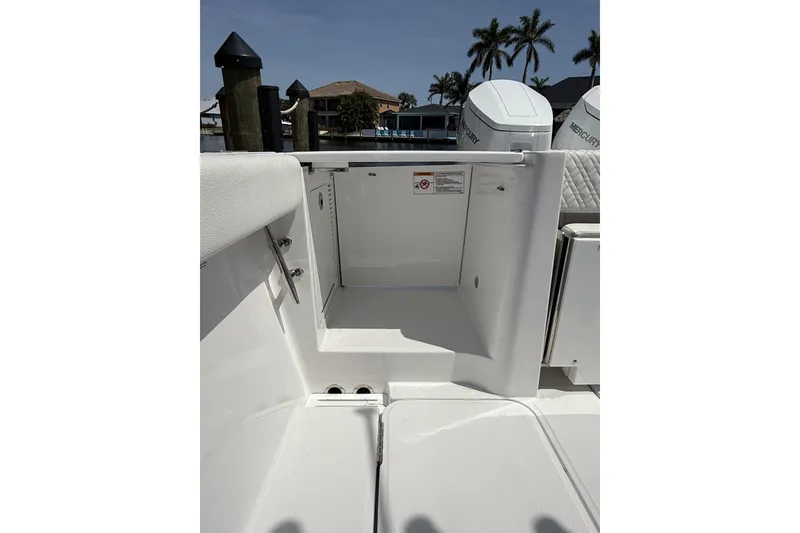 Slide: The Image of 2024 Bertram 39 CC boat interior with open storage compartment, docked near palm trees. - 35