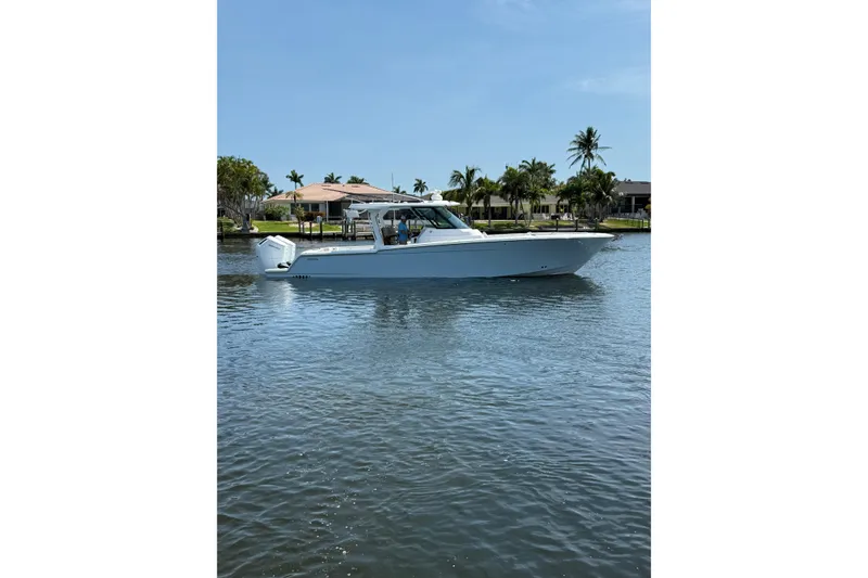 Slide: The Image of 2024 Bertram 39 CC boat on calm water with palm trees in the background. - 57