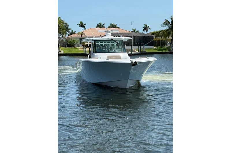 Slide: The Image of 2024 Bertram 39 CC boat cruising on a sunny day in a canal. - 59