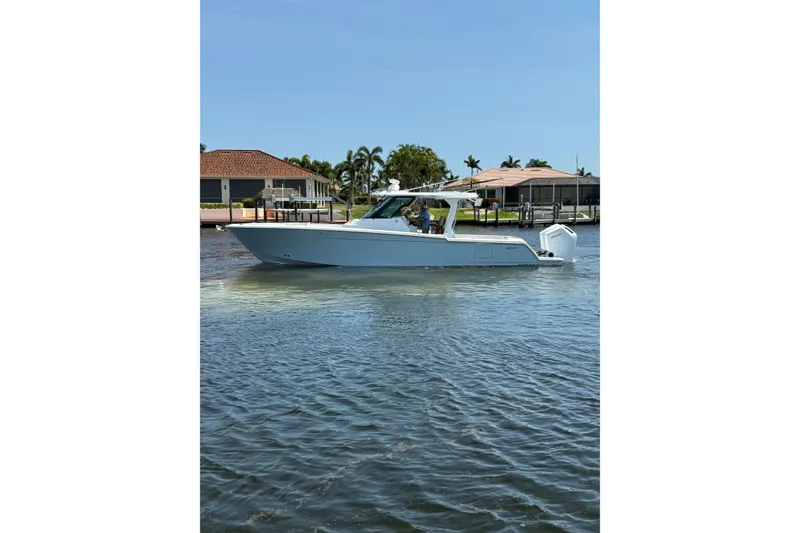 Slide: The Image of 2024 Bertram 39 CC boat cruising on a sunny day near waterfront homes. - 61
