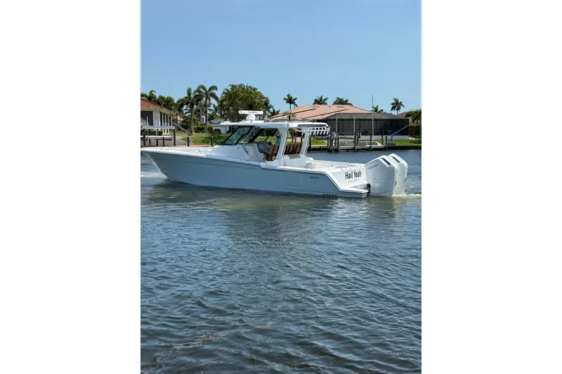 Slide: The Image of 2024 Bertram 39 CC boat cruising on a sunny day near waterfront homes. - 62
