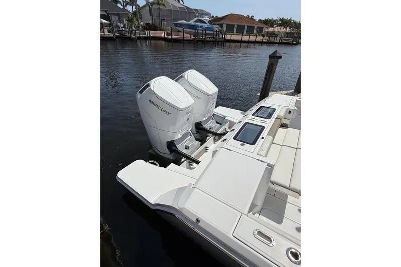 Slide: The Image of 2024 Bertram 39 CC boat with dual Mercury outboard engines docked by the water. - 65