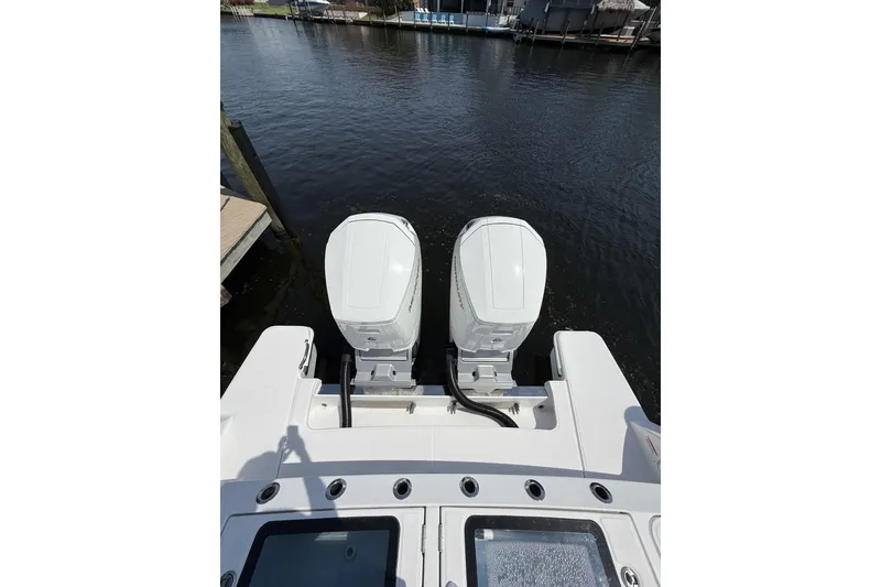 Slide: The Image of 2024 Bertram 39 CC boat with dual outboard engines on calm water. - 66