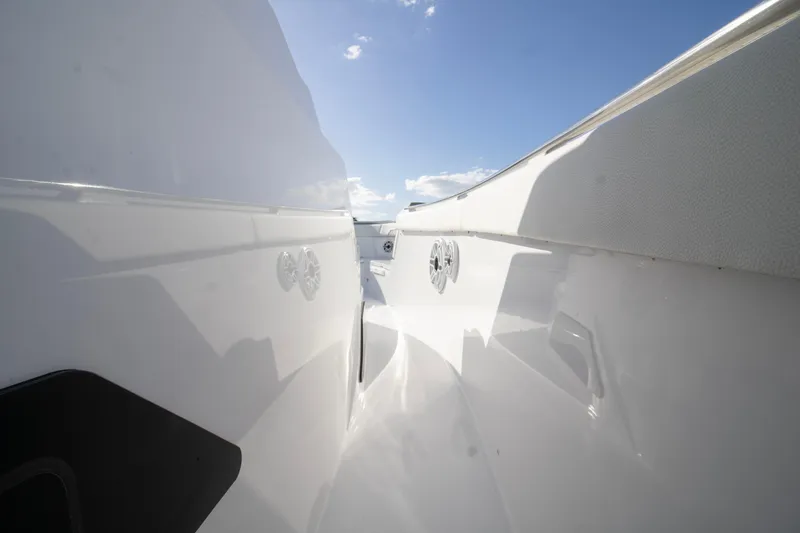 Slide: The Image of 2024 Bertram 39 CC boat deck with sleek white design under clear blue sky. - 74