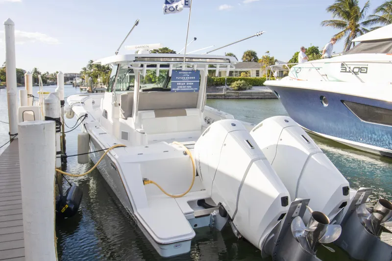 Slide: The Image of 2024 Bertram 39 CC boat docked with dual outboard engines, sunny marina setting. - 92