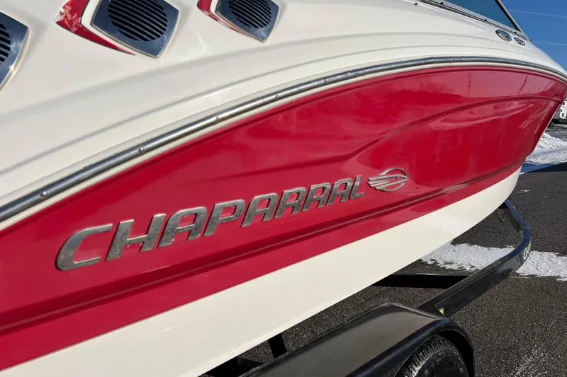 Slide: The Image of 2010 Chaparral 216 SSi boat with red and white exterior on a trailer. - 10