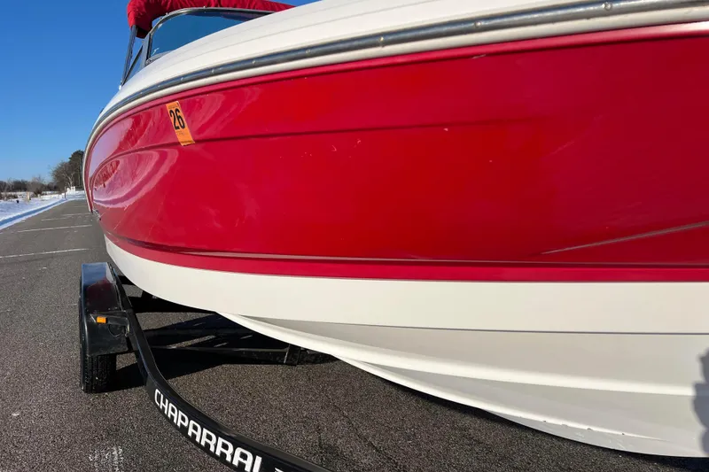 Slide: The Image of 2010 Chaparral 216 SSi boat with red and white exterior on a trailer. - 13