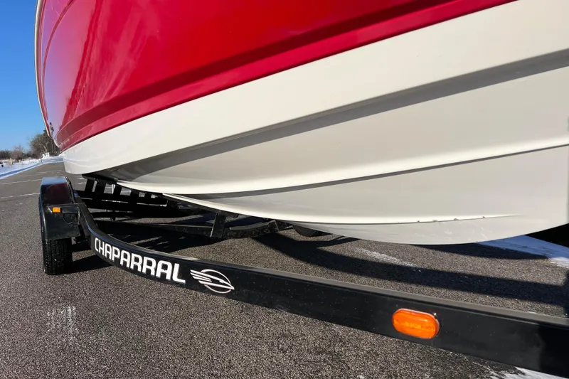 Slide: The Image of Chaparral 216 SSi 2010 boat on trailer, red and white hull, sunny day. - 14