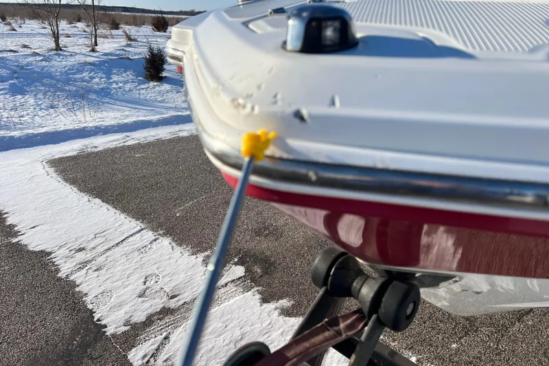 Slide: The Image of 2010 Chaparral 216 SSi boat with minor hull damage, parked on snowy pavement. - 16