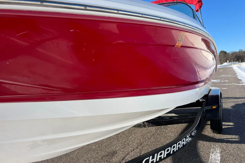 Slide: The Image of 2010 Chaparral 216 SSi boat with red and white hull on a trailer. - 19