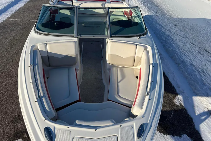 Slide: The Image of 2010 Chaparral 216 SSi boat with spacious seating, parked on snowy ground. - 2