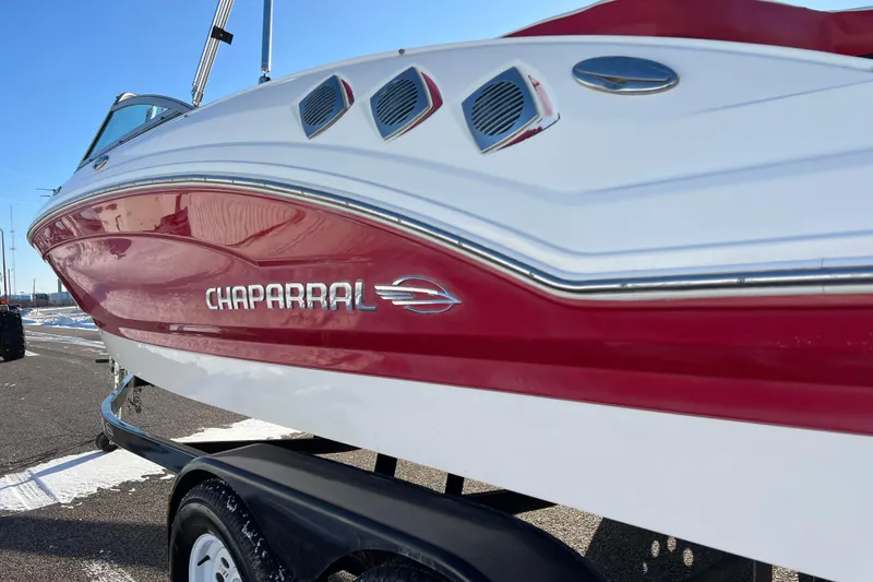 Slide: The Image of 2010 Chaparral 216 SSi boat with red and white exterior on a trailer. - 22